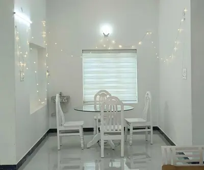 a dining room with a table and chairs and lights at White Cloud Stay Attappadi in Agali