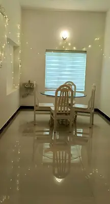 a dining room with a table and chairs and a window at White Cloud Stay Attappadi in Agali