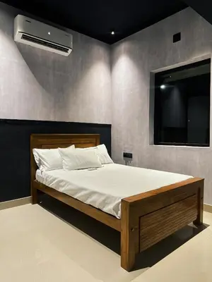 a bedroom with a bed with a tv on the wall at Ebb & Flow in Irimbranallūr