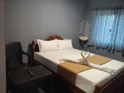 a bedroom with two beds and a chair with a pair of scissors at Msk indian Residency in Kodaikānāl