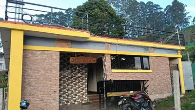 a building with a motorcycle parked in front of it at Msk indian Residency in Kodaikānāl