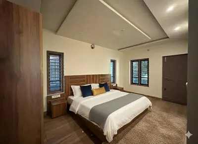 a bedroom with a large bed with blue pillows at Honeymoon holidays in Vythiri