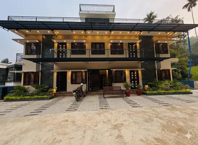 a house with a motorcycle parked in front of it at Honeymoon holidays in Vythiri