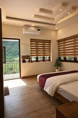 a bedroom with a bed and a large window at Honeymoon holidays in Vythiri