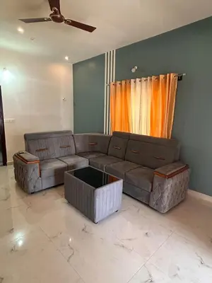 a living room with a brown couch and a window at Aarvani Retreat Relax, Explore & Unwind in Coorg in Kushālnagar