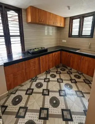 a kitchen with a tiled floor and a counter top at Aarvani Retreat Relax, Explore & Unwind in Coorg in Kushālnagar