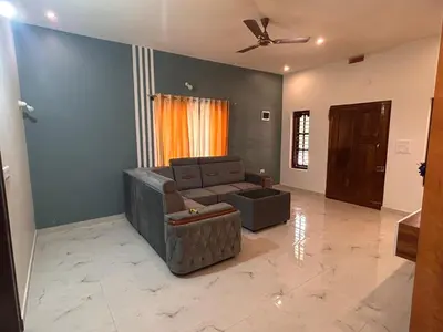 a living room with a couch and a ceiling fan at Aarvani Retreat Relax, Explore & Unwind in Coorg in Kushālnagar