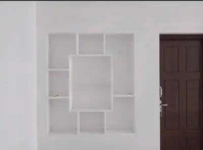 a white book shelf in a white room with a door at Aswathy Bhavan in Vadakkāncheri