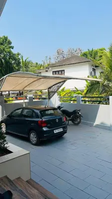 a car parked in a parking lot in front of a house at Parthipuram in Thottada