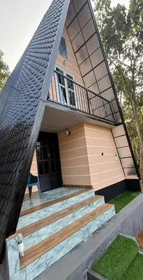 a house with a gambrel roof with stairs in front at Zerahs Private Pool Villa, Athirappilly - Extra upstair Bed space in Athirappally