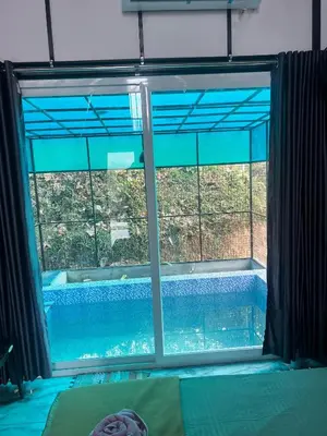 a view of a swimming pool through a window at Zerahs Private Pool Villa, Athirappilly - Extra upstair Bed space in Athirappally