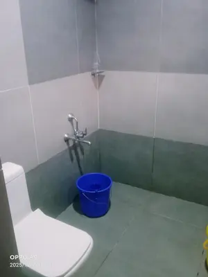a bathroom with a toilet and a bucket at Puthooram Veedu in Kannur