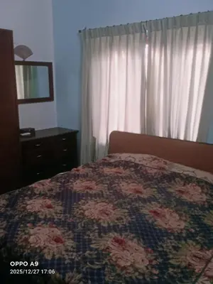 a bedroom with a bed with a floral quilt on it at Puthooram Veedu in Kannur