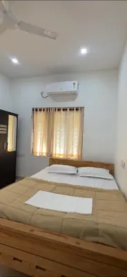 a bedroom with a large bed and a window at Moksha Farm Stay in Edappāl