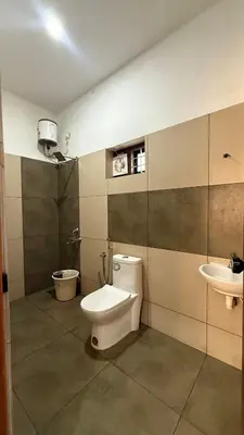 a bathroom with a toilet and a sink at Moksha Farm Stay in Edappāl