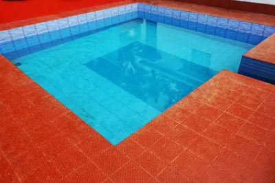 a large swimming pool with blue tiles on the floor at Moksha Farm Stay in Edappāl
