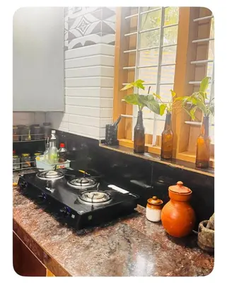 a stove top in a kitchen with a window at Nirvana Stays Banasura -Lotus in Wayanad