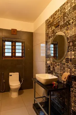 a bathroom with a toilet and a sink and a mirror at 1st Miracle By Mirth, Mythadi , Coorg in Ammatti
