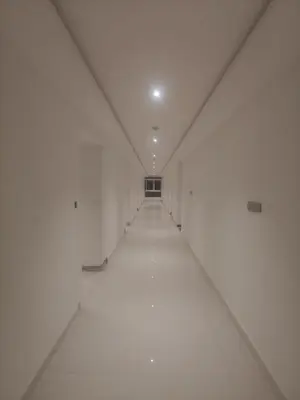 an empty hallway in a white building with a white ceiling at Mysore Comforts Stay in Mysore