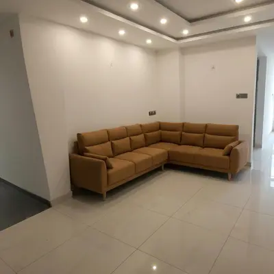 a brown couch in a room with a white wall at Mysore Comforts Stay in Mysore