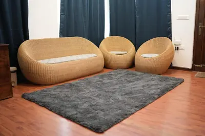 two wicker chairs and a rug in a room at Vaj N Sat Villas in Kodaikānāl