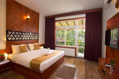 a bedroom with a large bed and a large window at Karlad Lake Resort in Wayanad