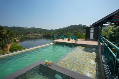 a swimming pool with a view of a river at Karlad Lake Resort in Wayanad