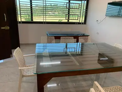 a glass table and chairs in a room at Elysian in Mananthavady