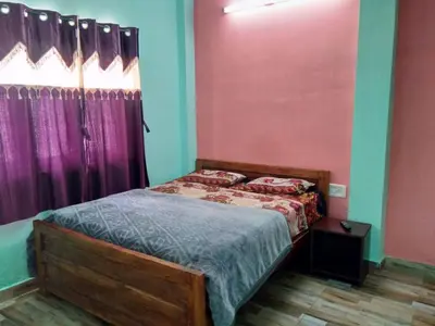 a bedroom with a bed and purple walls at Nira Homestay in Kodaikānāl