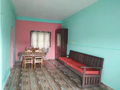 a room with a bench and a dining room with a table at Nira Homestay in Kodaikānāl