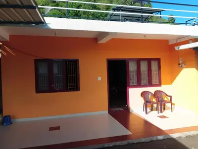 two chairs sitting on the porch of a house at Nira Homestay in Kodaikānāl