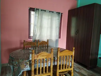 a dining room with a table and four chairs at Nira Homestay in Kodaikānāl