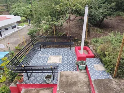 an overhead view of three park benches on a patio at Nira Homestay in Kodaikānāl