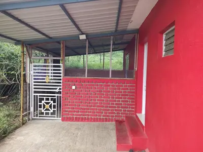 a red building with a red door and a red wall at Nira Homestay in Kodaikānāl