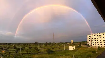 a double rainbow in the sky over a city at Campside Stays in Nāganahalli