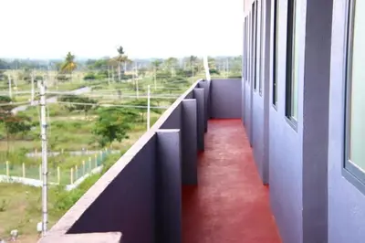 a corridor of a building with a red floor and windows at Campside Stays in Nāganahalli