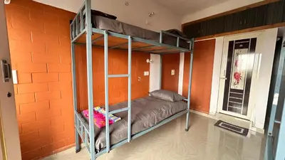 a bunk bed in a room with an orange wall at Campside Stays in Nāganahalli