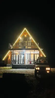 a car parked in front of a house at night at Kacchi Kombu Castle By Calpavruksha Estate in Madikeri