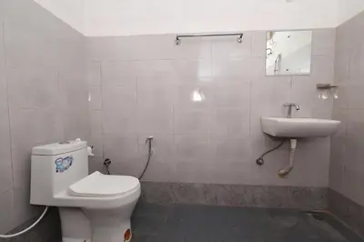 a bathroom with a toilet and a sink at Vayuvana Heritage Organic Farm Resort in Panamaram
