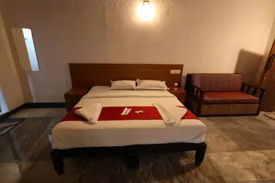 a bedroom with a bed with a red blanket at Vayuvana Heritage Organic Farm Resort in Panamaram