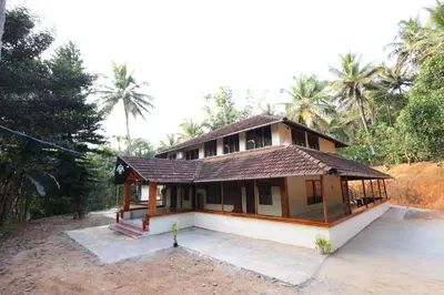 a small house in the middle of a forest at Vayuvana Heritage Organic Farm Resort in Panamaram