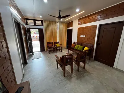 a living room with a table and chairs and a ceiling fan at 3 bhk Premium home Stay at Ernakulam Aluva Perfect for Family and Long stay in Alwaye