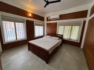 a bedroom with a bed and two windows at 3 bhk Premium home Stay at Ernakulam Aluva Perfect for Family and Long stay in Alwaye
