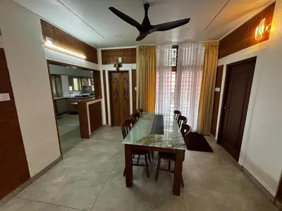 a dining room with a table and a ceiling fan at 3 bhk Premium home Stay at Ernakulam Aluva Perfect for Family and Long stay in Alwaye