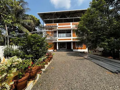 a building with potted plants in front of it at 3 bhk Premium home Stay at Ernakulam Aluva Perfect for Family and Long stay in Alwaye