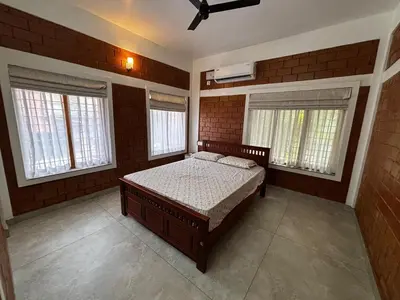 a bedroom with a bed and two windows at 3 bhk Premium home Stay at Ernakulam Aluva Perfect for Family and Long stay in Alwaye