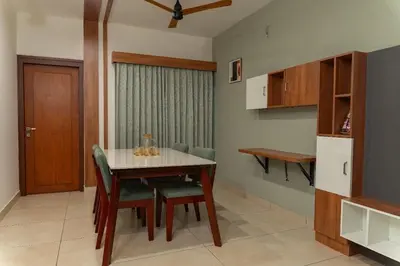 a kitchen and dining room with a table and chairs at Couple friendly apartment in Kozhikode