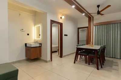 a dining room with a table and a bathroom at Couple friendly apartment in Kozhikode