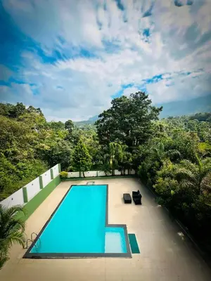 a blue swimming pool on top of a house at Girassol Serviced Villa in Vythiri