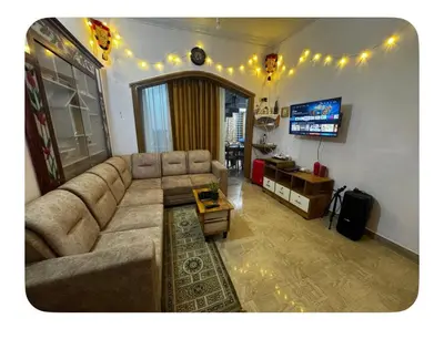 a living room with a couch and a tv at NirvanaStays-Blooms in Tariyod